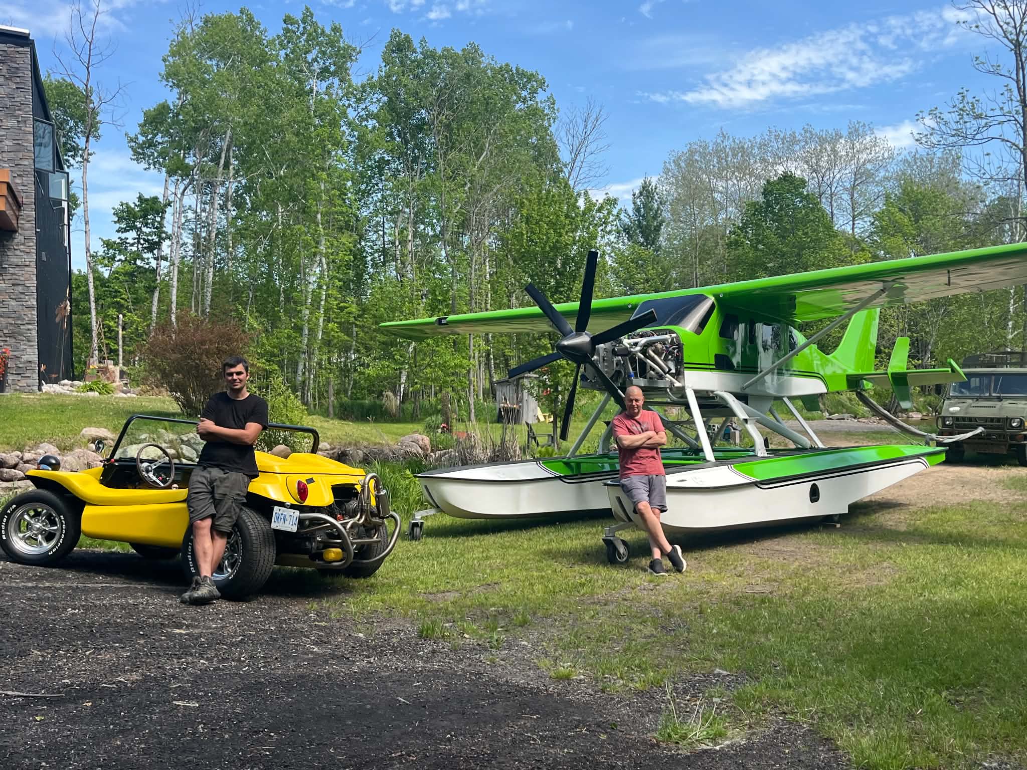 Andrii Zolotai standing beside his yellow Manx dune buggy and a green floatplane