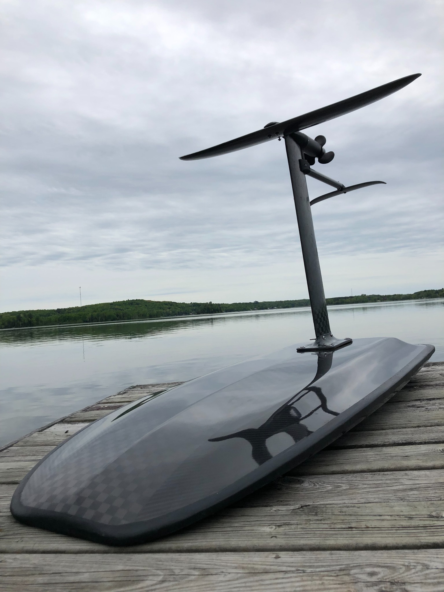 Completed carbon-fibre electric hydrofoil board standing on a dock