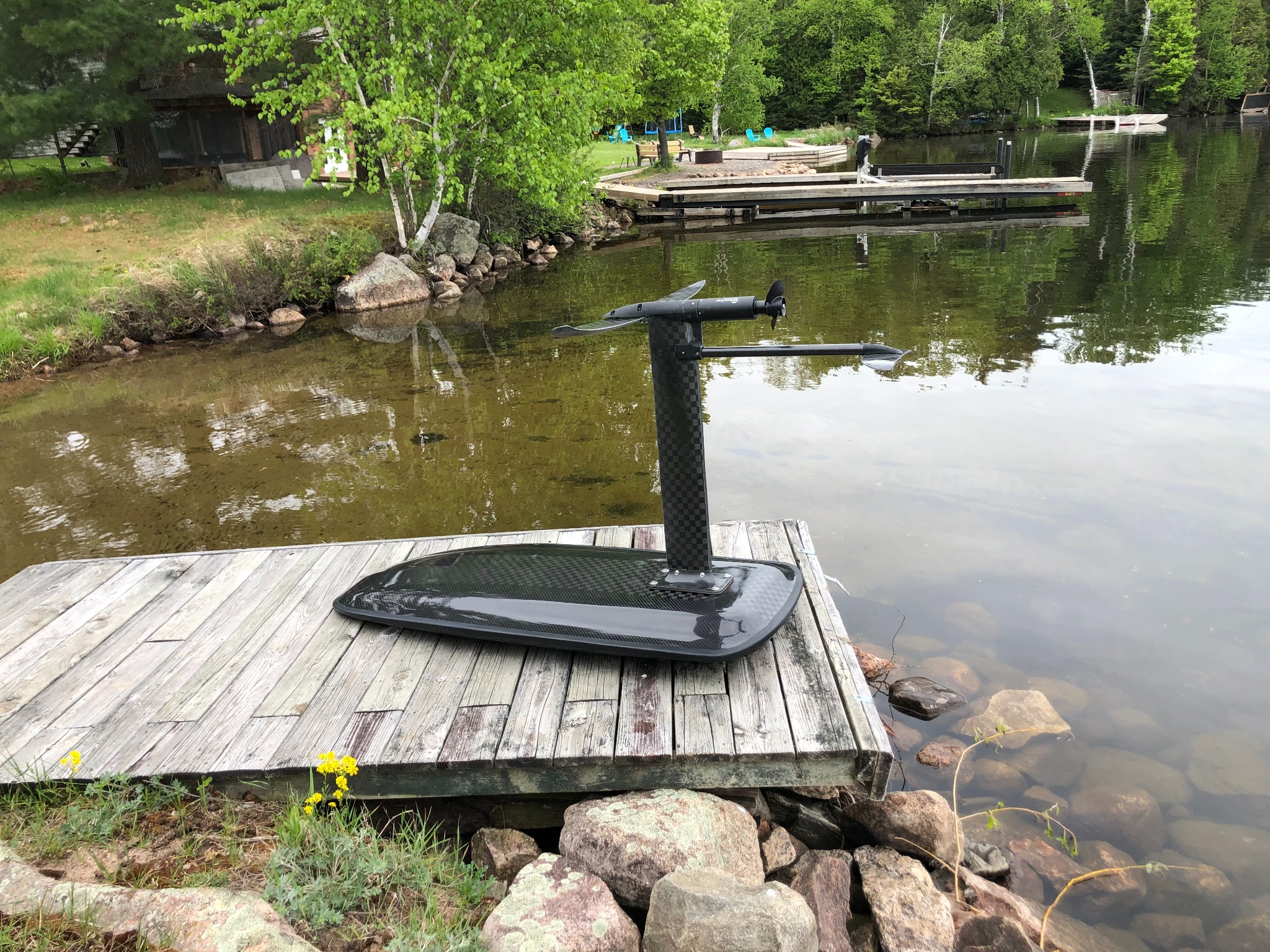Completed electric hydrofoil board resting beside a lake