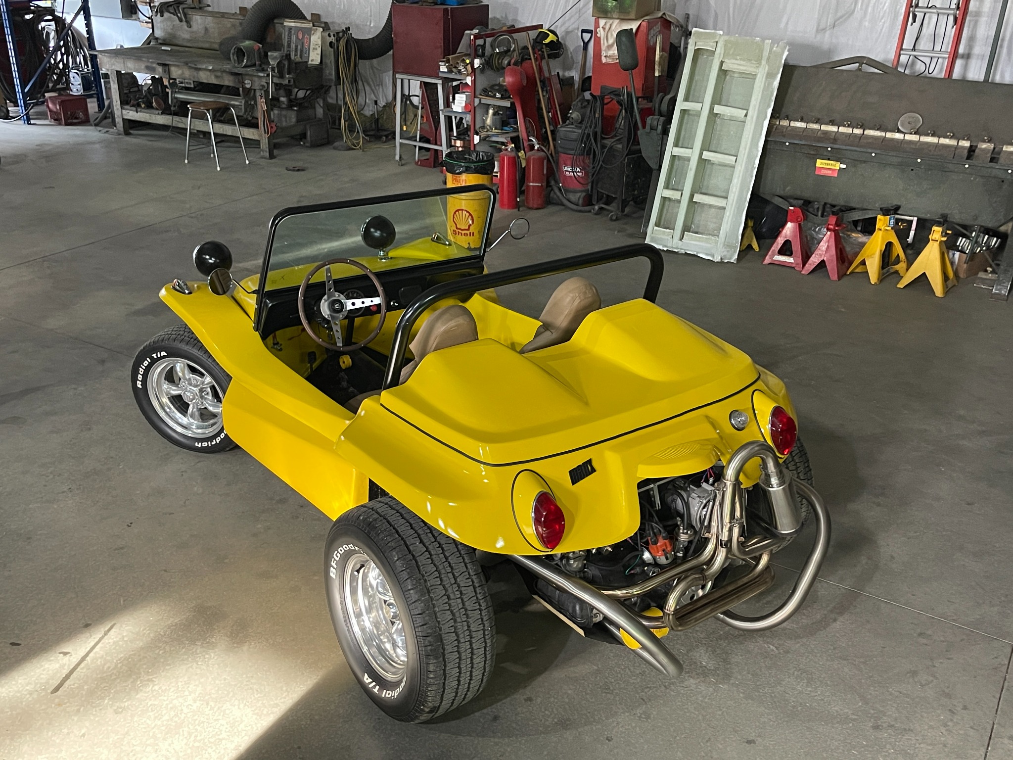 High rear view of the completed yellow Manx dune buggy in the workshop