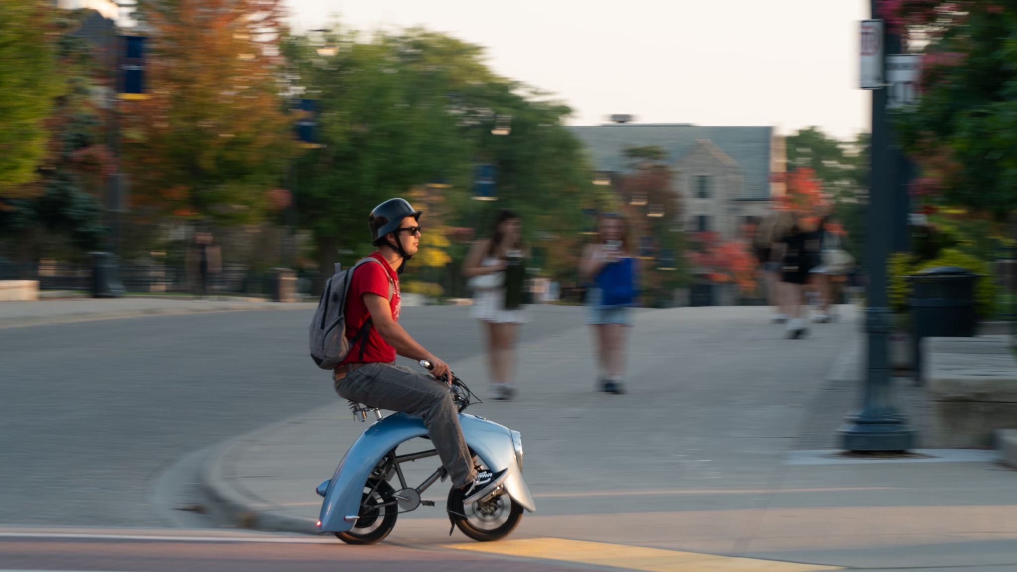 Andrii riding the completed blue electric mini bike through the city