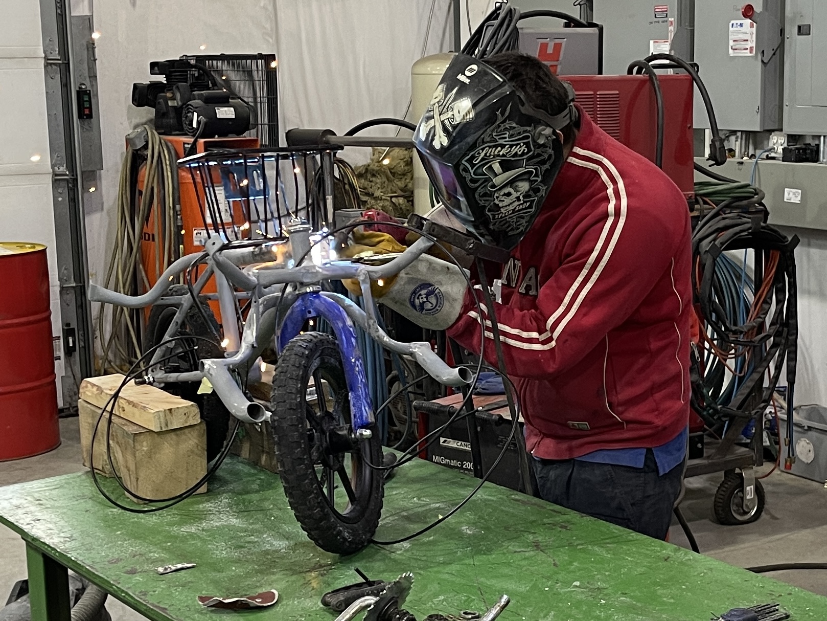 Andrii welding the custom mini bike structure on a workbench