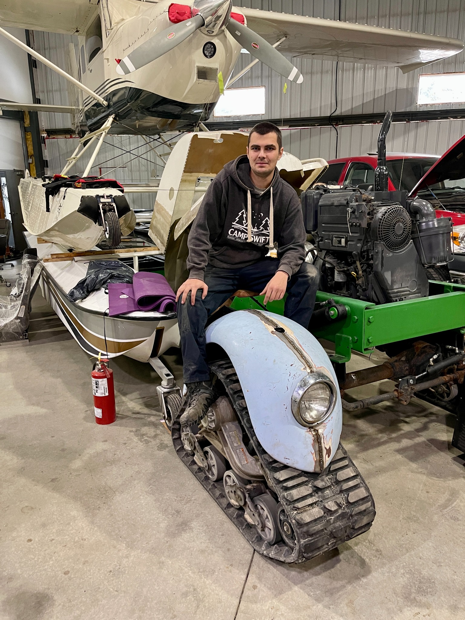 Andrii seated on the partially assembled mini bike during a workshop fit check
