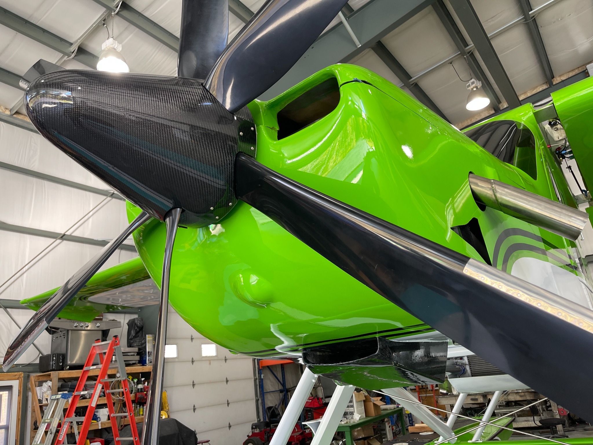 Carbon-fibre aircraft spinner installed on a green airplane