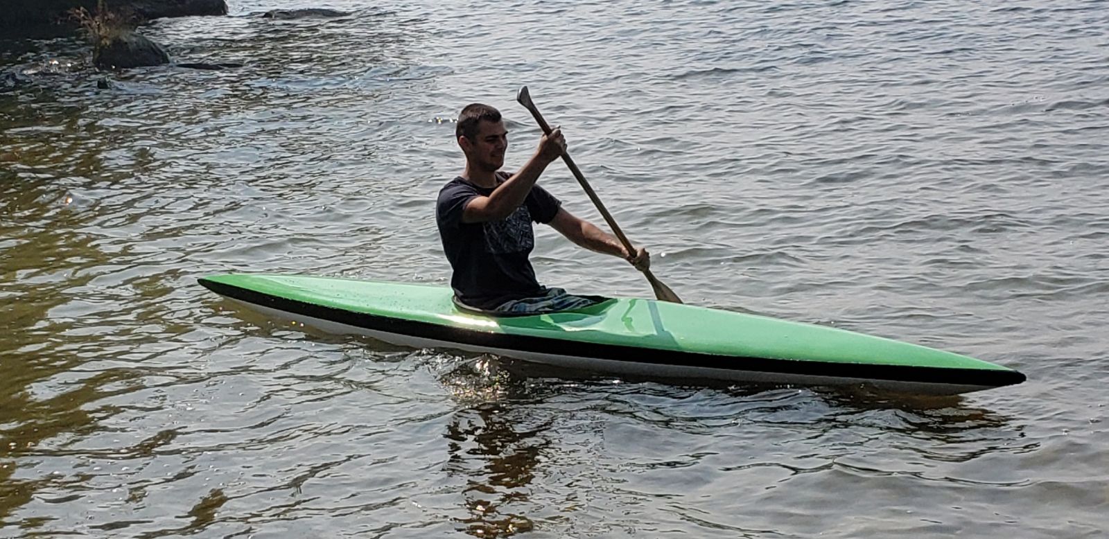 Andrii paddling the completed green whitewater kayak